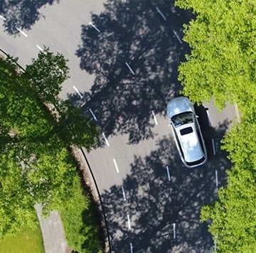 Véhicule circulant sur une route ombragée